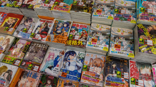 Différents mangas empilés sur une table dans une librairie japonaise