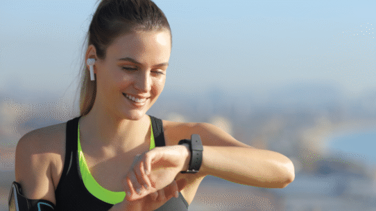 Femme souriante en tenue de sport utilisant une montre connectée