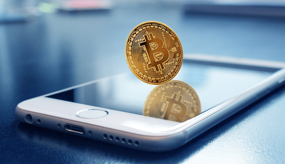 Pièce de Bitcoin flottant au-dessus d'un smartphone