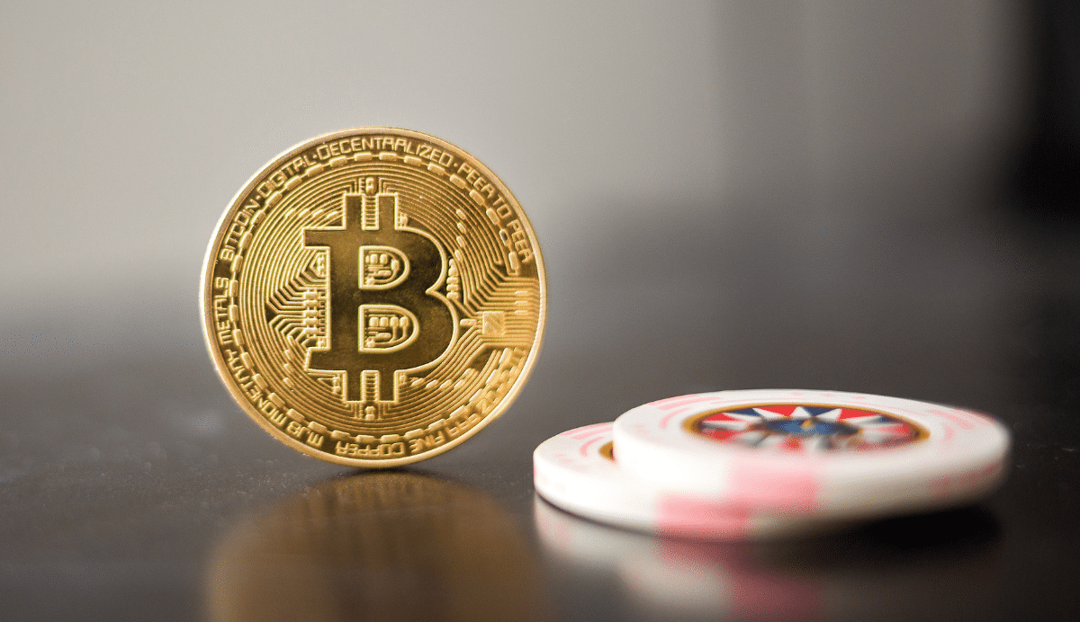 Pièce de bitcoin en or et jetons de casino sur une table