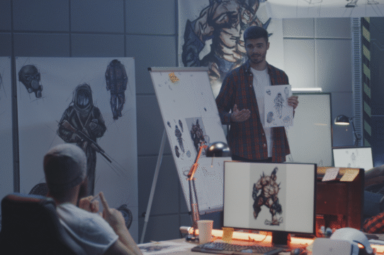 Homme présentant des croquis de personnages de jeu vidéo lors d'une réunion.