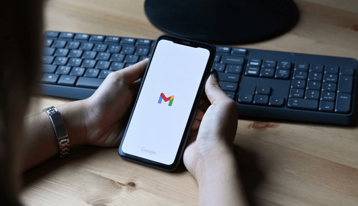 Personne tenant un smartphone avec l'application Gmail ouverte