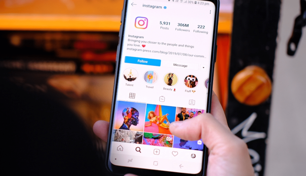 Main tenant un téléphone affichant un profil Instagram