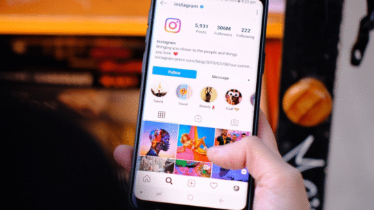 Main tenant un téléphone affichant un profil Instagram