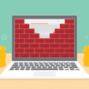 Ordinateur avec mur de briques et piles de pièces d'or