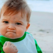 Bébé avec expression déterminée tenant du sable sur la plage