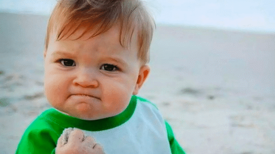 Bébé avec expression déterminée tenant du sable sur la plage