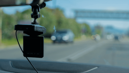 Caméra de tableau de bord filmant la route depuis une voiture.