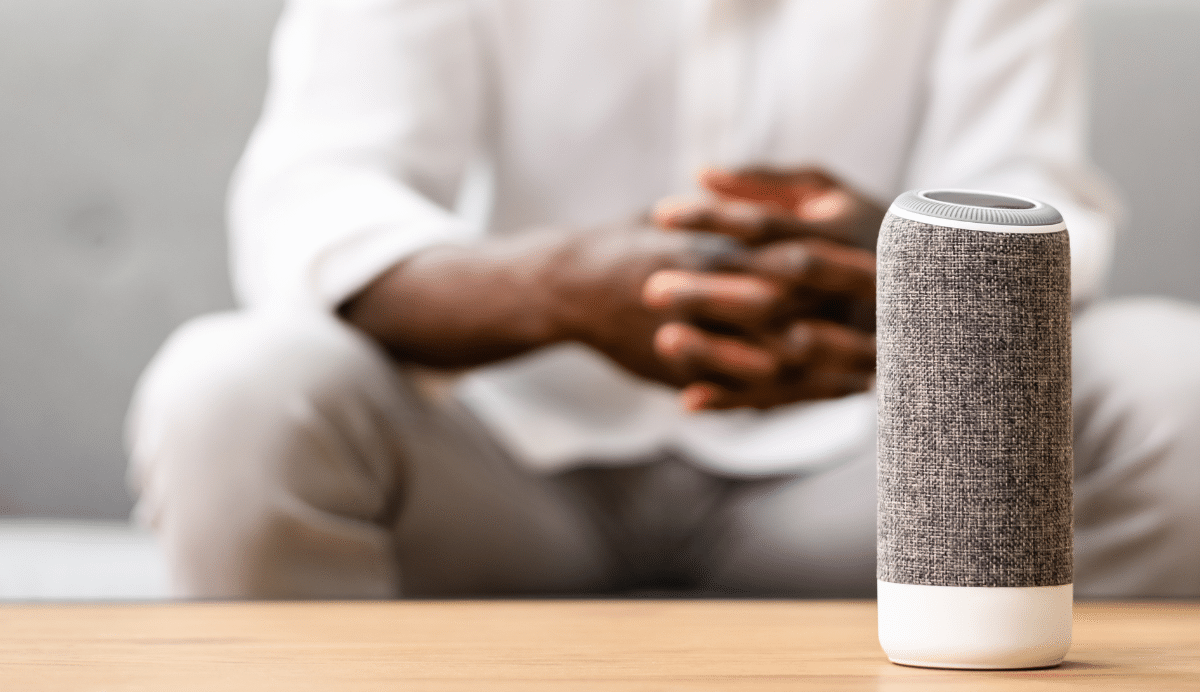 Enceinte connectée sur une table avec une personne en arrière-plan