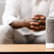 Enceinte connectée sur une table avec une personne en arrière-plan
