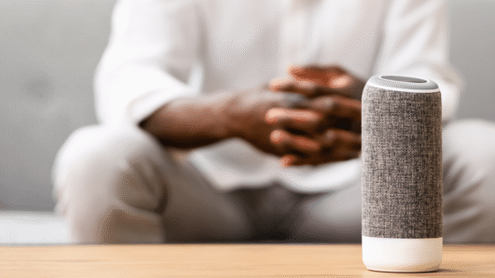 Enceinte connectée sur une table avec une personne en arrière-plan