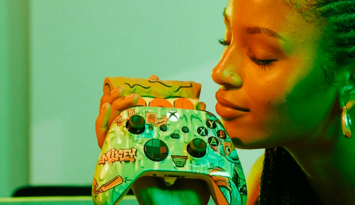 Femme tenant une manette de jeu personnalisée contre son visage