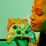 Femme tenant une manette de jeu personnalisée contre son visage