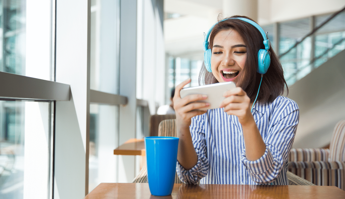 Femme avec casque bleu écoutant de la musique sur smartphone
