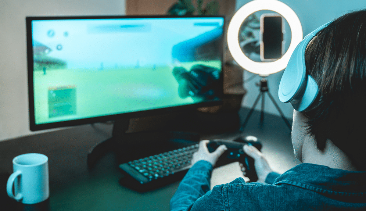 Personne jouant à un jeu vidéo sur écran avec casque et manette