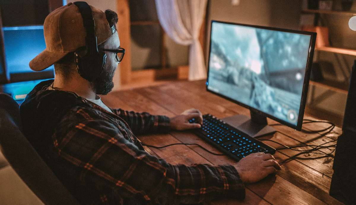 Homme jouant à un jeu vidéo sur ordinateur à son bureau