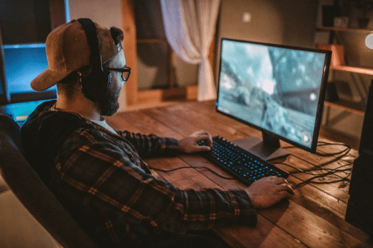 Homme jouant à un jeu vidéo sur ordinateur à son bureau