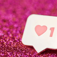 Icône de j'aime avec un cœur sur fond rose scintillant