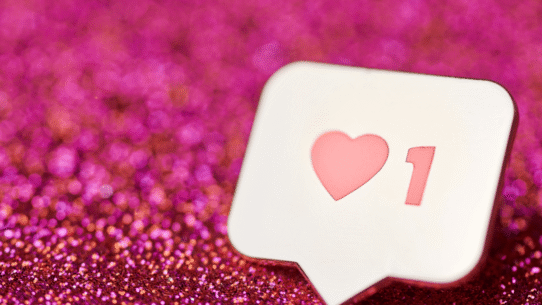 Icône de j'aime avec un cœur sur fond rose scintillant