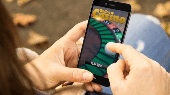 Main tenant un smartphone avec un jeu de casino en ligne