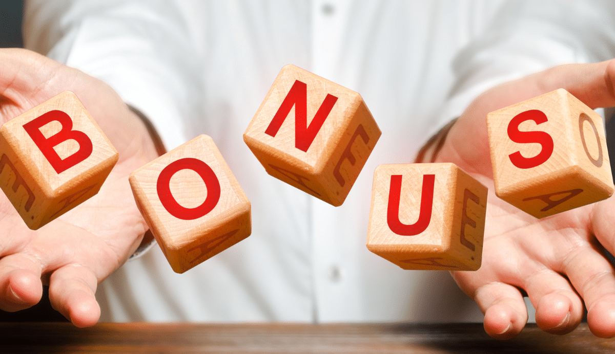 Main tenant des cubes en bois avec le mot bonus