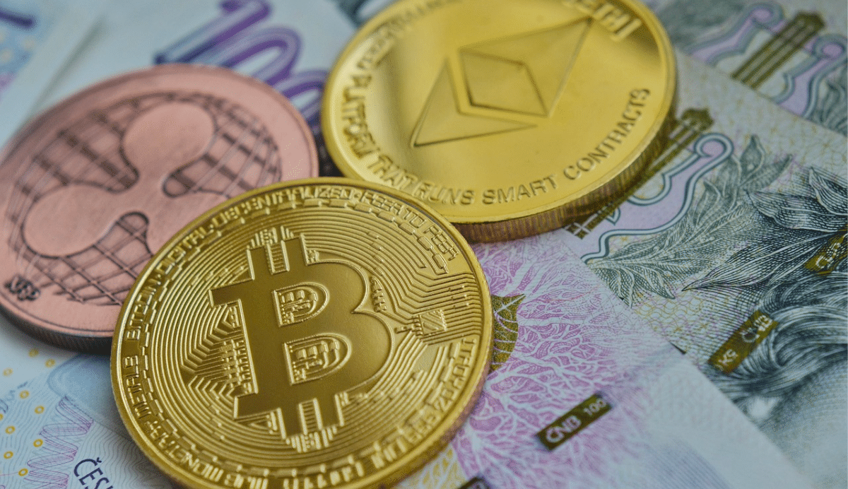 Pièces de Bitcoin, Ethereum et Ripple sur des billets de banque