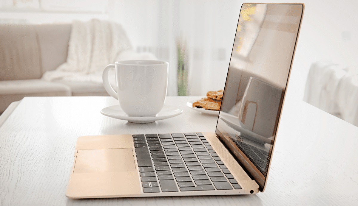 Ordinateur portable sur une table avec une tasse et des biscuits