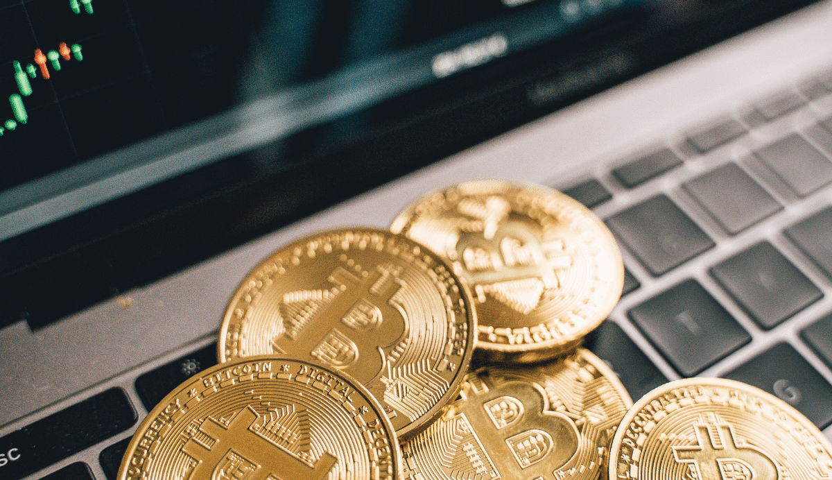 Pièces de bitcoin sur un clavier avec graphique en arrière-plan