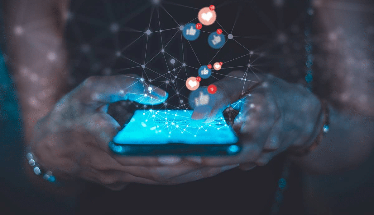 Main tenant un smartphone avec des icônes de réseaux sociaux flottants