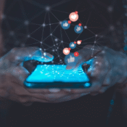 Main tenant un smartphone avec des icônes de réseaux sociaux flottants