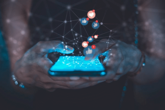 Main tenant un smartphone avec des icônes de réseaux sociaux flottants