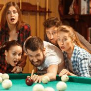 Groupe d'amis fascinés par une partie de billard