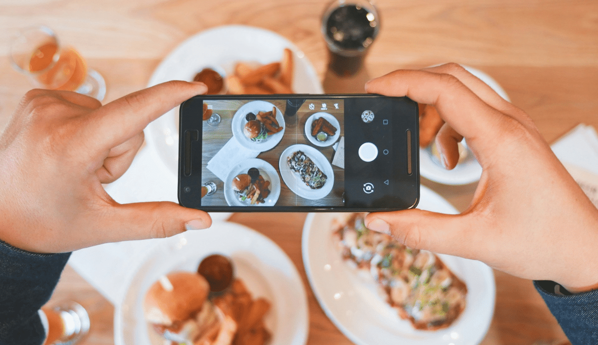 Personne prenant une photo d'assiettes avec un smartphone