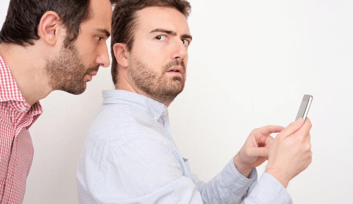 Deux hommes, l'un vérifiant le téléphone de l'autre