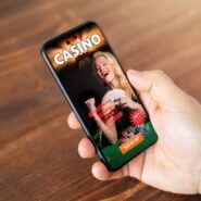 Main tenant un smartphone affichant une application de casino