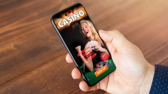 Main tenant un smartphone affichant une application de casino