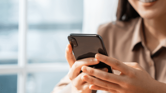 Femme souriante tenant un smartphone