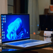 Ordinateur portable ouvert sur un bureau en verre avec fond flou