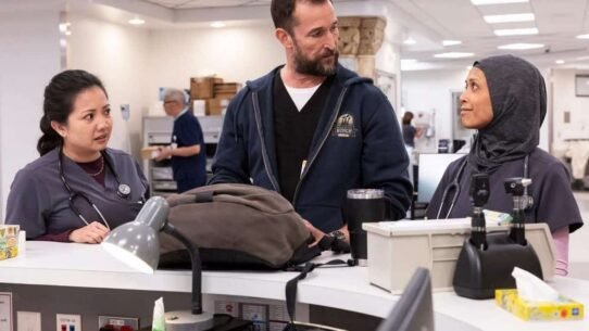 Trois professionnels de santé discutent autour d'un bureau dans un hôpital