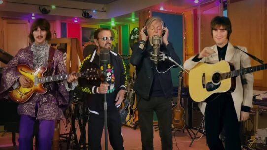 Quatre musiciens en studio avec guitares et micro