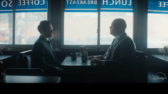 Deux hommes en costume discutent dans un café