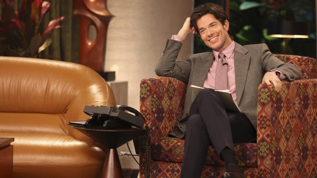 Homme souriant assis sur un canapé de télévision