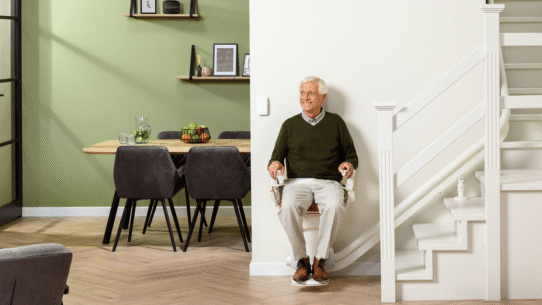 Homme souriant assis sur un monte-escalier dans un intérieur moderne