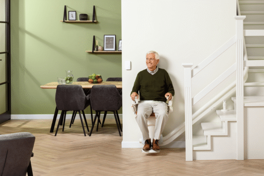 Homme souriant assis sur un monte-escalier dans un intérieur moderne