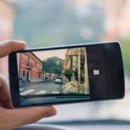 Main tenant un smartphone capturant une rue de village