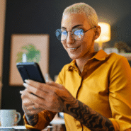 Femme souriante utilisant un smartphone dans un bureau moderne