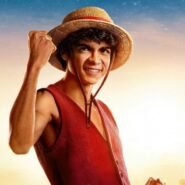 Personnage souriant avec un chapeau de paille et un poing levé