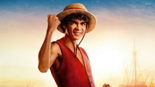 Personnage souriant avec un chapeau de paille et un poing levé