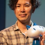 Homme avec une chemise à carreaux tenant une figurine