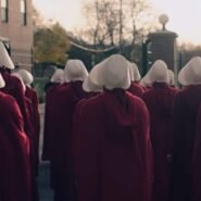 Femmes en robes rouges et bonnets blancs marchant ensemble